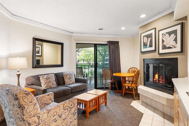 living room with a tiled fireplace, a textured ceiling, tile patterned floors, and crown molding