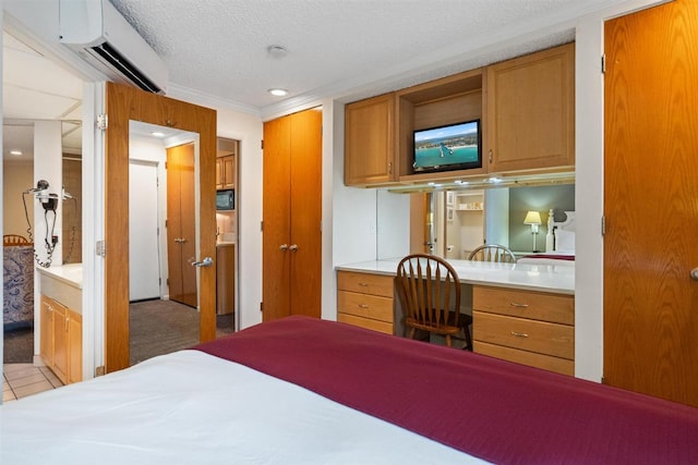 bedroom featuring a textured ceiling, light tile patterned floors, and a wall unit AC