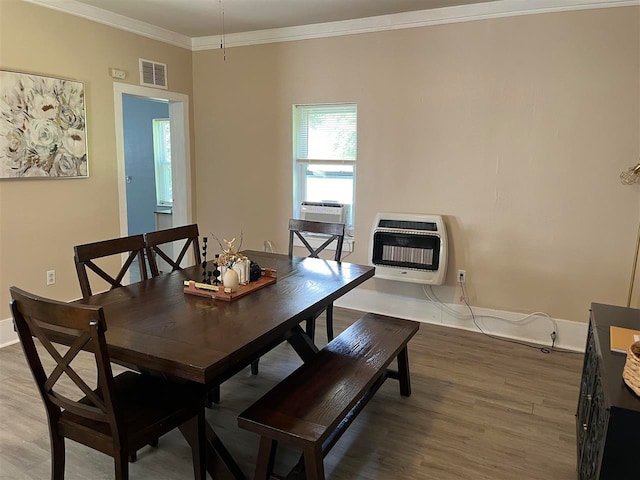 dining area with ornamental molding and hardwood / wood-style flooring