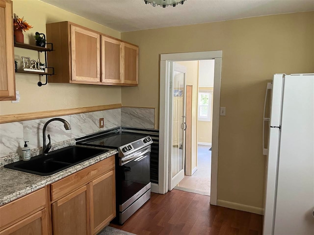 kitchen with electric range, tasteful backsplash, white refrigerator, sink, and dark wood-type flooring