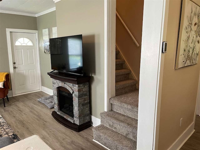 interior space featuring a fireplace, ornamental molding, and hardwood / wood-style floors