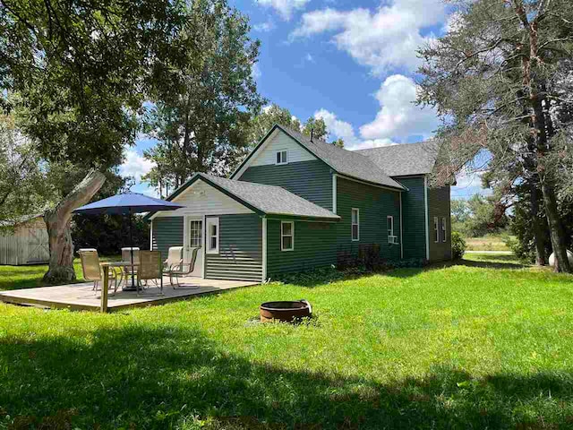 back of house featuring a yard and an outdoor fire pit