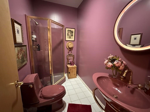 bathroom featuring tile patterned flooring, toilet, a shower with door, and sink