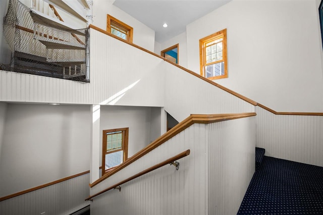 staircase with recessed lighting, a wainscoted wall, and carpet floors