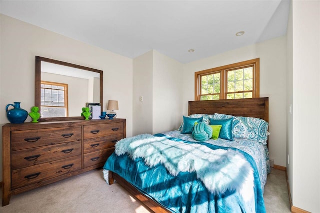 bedroom featuring multiple windows and light carpet