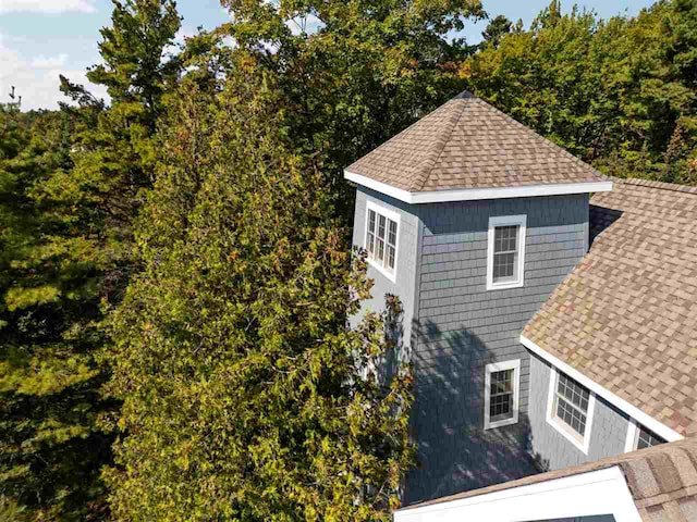 view of side of property featuring roof with shingles