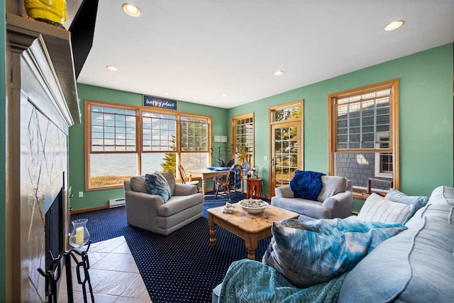 living area featuring a premium fireplace, plenty of natural light, recessed lighting, and a baseboard radiator