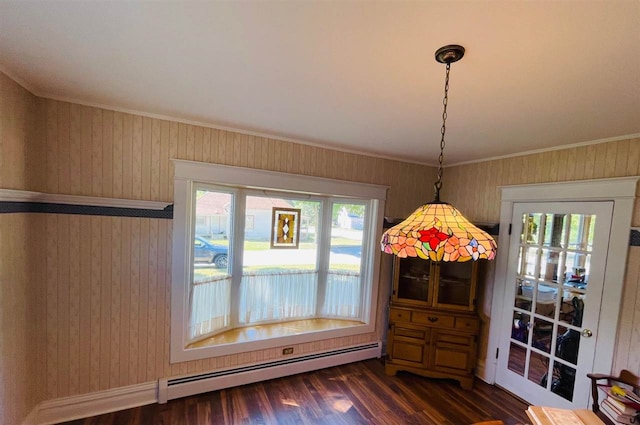 unfurnished dining area with ornamental molding, dark wood-type flooring, and a baseboard heating unit