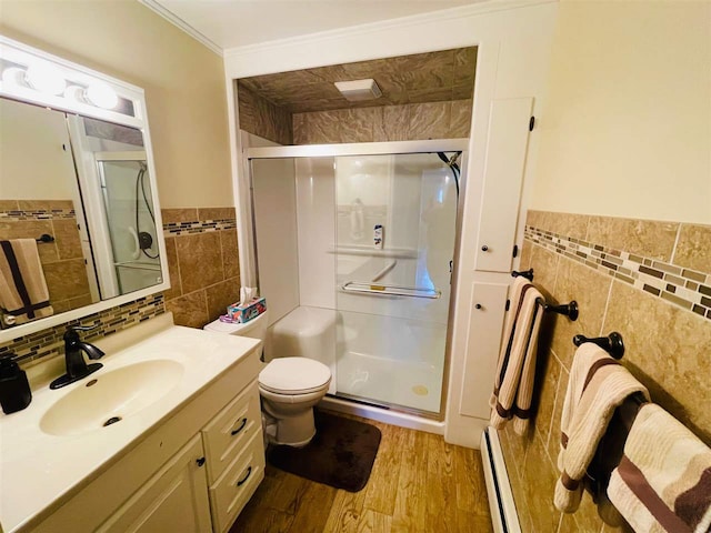 bathroom with vanity, hardwood / wood-style floors, ornamental molding, toilet, and a shower with door