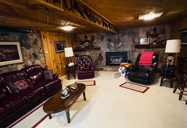 carpeted living room featuring wooden walls, a fireplace, and wooden ceiling