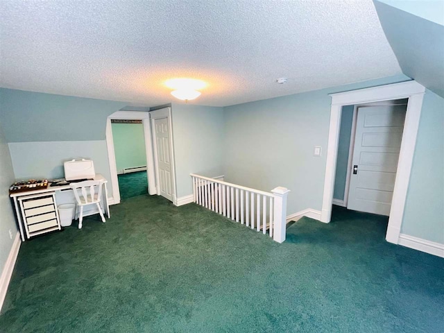 bonus room with a textured ceiling, baseboard heating, and dark colored carpet