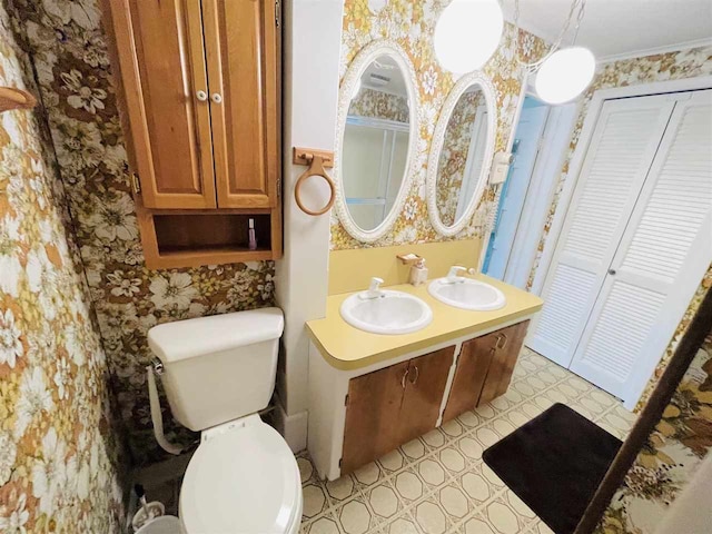 bathroom with crown molding, vanity, and toilet