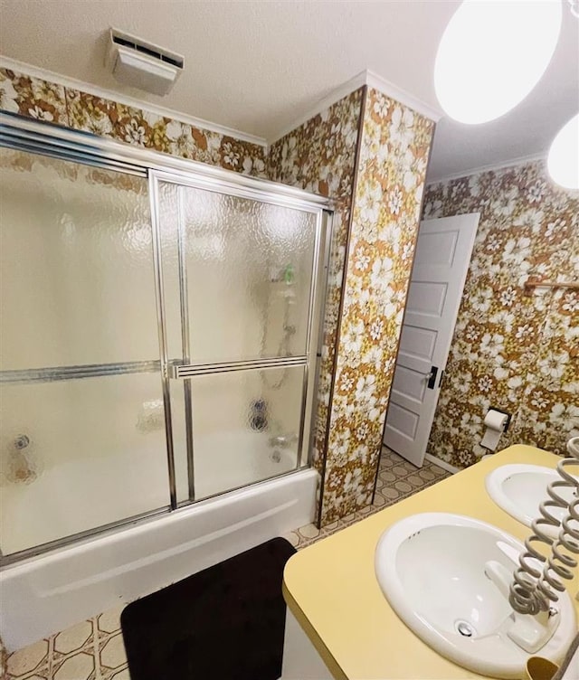 bathroom with shower / bath combination with glass door, vanity, and crown molding