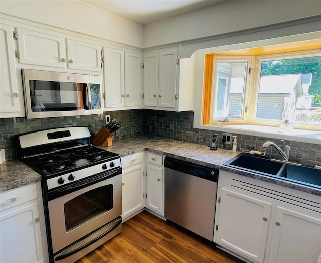 kitchen featuring appliances with stainless steel finishes, decorative backsplash, dark hardwood / wood-style flooring, and white cabinets