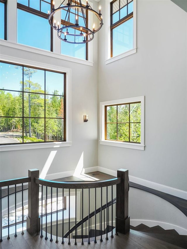 11305 Evergreen Ln, Charlevoix, MI 49720 - stairs featuring a chandelier, wood finished floors, baseboards, and a towering ceiling