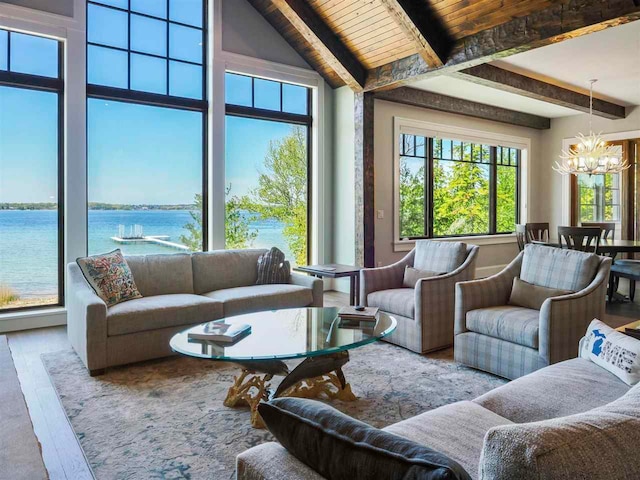 living room featuring a chandelier, high vaulted ceiling, hardwood / wood-style floors, beam ceiling, and a water view