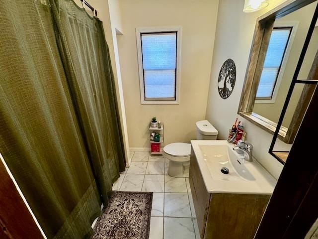 bathroom featuring tile patterned floors, vanity, a healthy amount of sunlight, and toilet