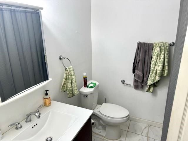 bathroom featuring toilet, vanity, and tile patterned floors