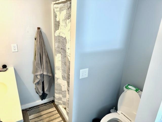 bathroom featuring toilet and a shower with shower curtain