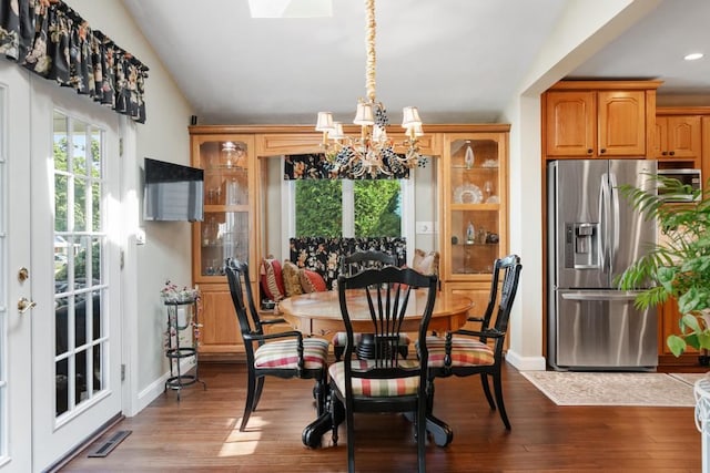 dining area with light hardwood / wood-style floors, a chandelier, and lofted ceiling