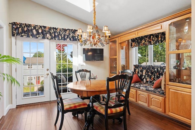 dining room with a notable chandelier, dark hardwood / wood-style flooring, and lofted ceiling