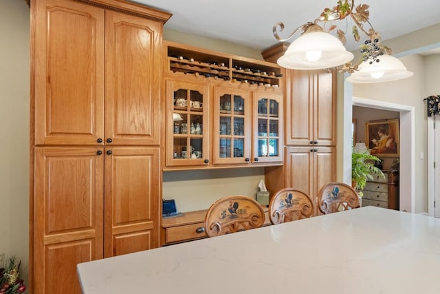 kitchen with hanging light fixtures and light stone countertops