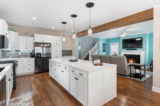 kitchen with open floor plan, light countertops, appliances with stainless steel finishes, and white cabinetry