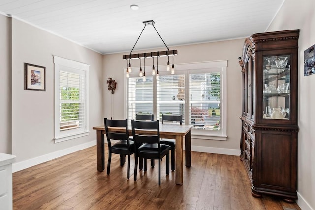 dining room with ornamental molding, baseboards, and wood finished floors