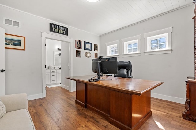 office area featuring light wood-type flooring, visible vents, and baseboards