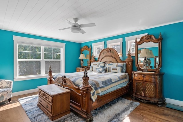 bedroom with wood ceiling, wood finished floors, a ceiling fan, and baseboards