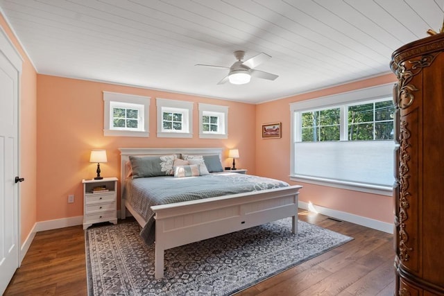 bedroom featuring dark wood-style flooring, a ceiling fan, and baseboards