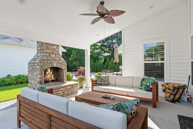 view of patio / terrace featuring an outdoor living space with a fireplace and a ceiling fan