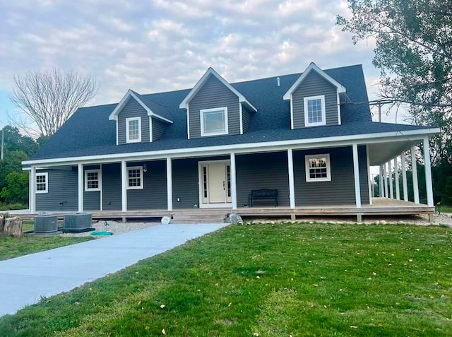 country-style home with a front yard, covered porch, and central AC unit