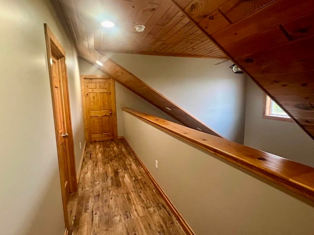 hallway featuring vaulted ceiling, hardwood / wood-style flooring, and wooden ceiling