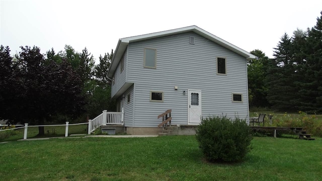 rear view of property featuring a yard