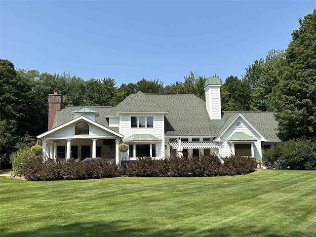 645 Woodhill Ct, Harbor Springs, MI 49740 - view of front of house with a front lawn, roof with shingles, and a chimney