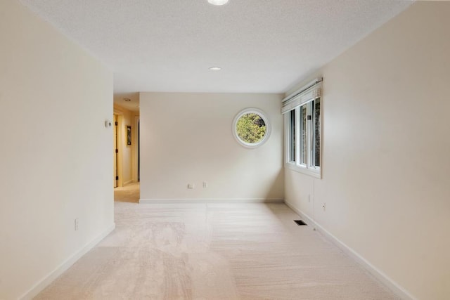 645 Woodhill Ct, Harbor Springs, MI 49740 - carpeted spare room with visible vents, baseboards, and a textured ceiling