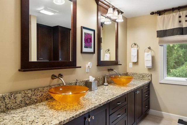 645 Woodhill Ct, Harbor Springs, MI 49740 - bathroom with double vanity, baseboards, visible vents, and a sink