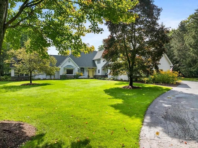 645 Woodhill Ct, Harbor Springs, MI 49740 - view of front of house featuring stone siding and a front lawn