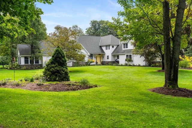 645 Woodhill Ct, Harbor Springs, MI 49740 - view of front of property with stone siding, a front yard, and roof with shingles