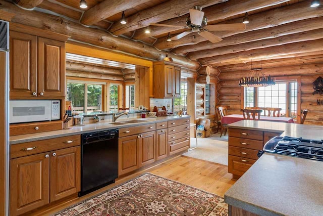 kitchen with black dishwasher, rustic walls, and light hardwood / wood-style floors