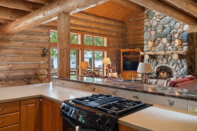 kitchen featuring gas stove, wooden ceiling, a stone fireplace, rustic walls, and vaulted ceiling with beams