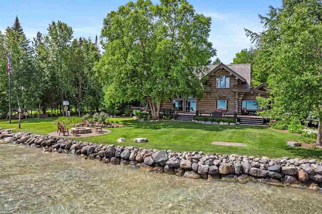 back of house featuring a yard, a fire pit, and a deck