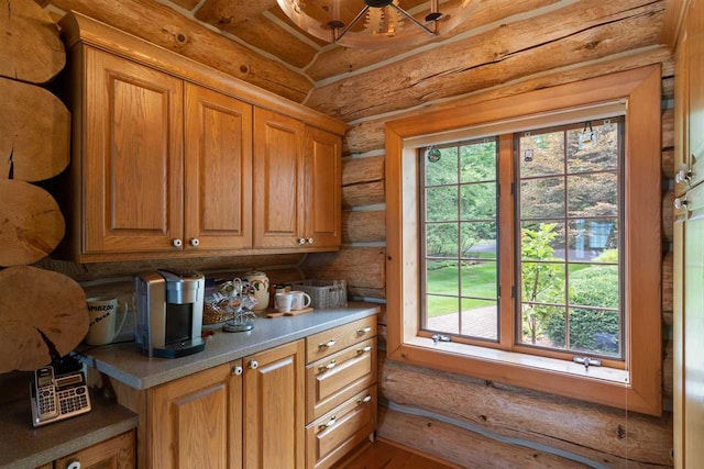 kitchen with log walls and wood-type flooring