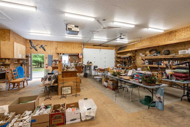 garage with a workshop area, a garage door opener, and ceiling fan