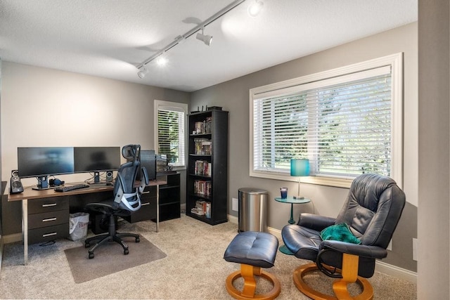 carpeted home office featuring rail lighting and a textured ceiling