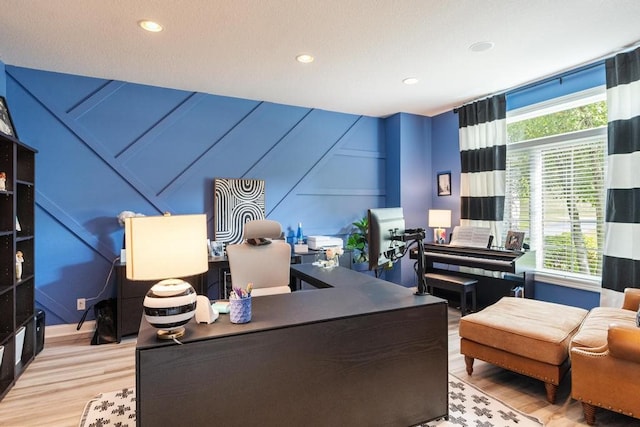 home office featuring a wealth of natural light, light hardwood / wood-style floors, and a textured ceiling