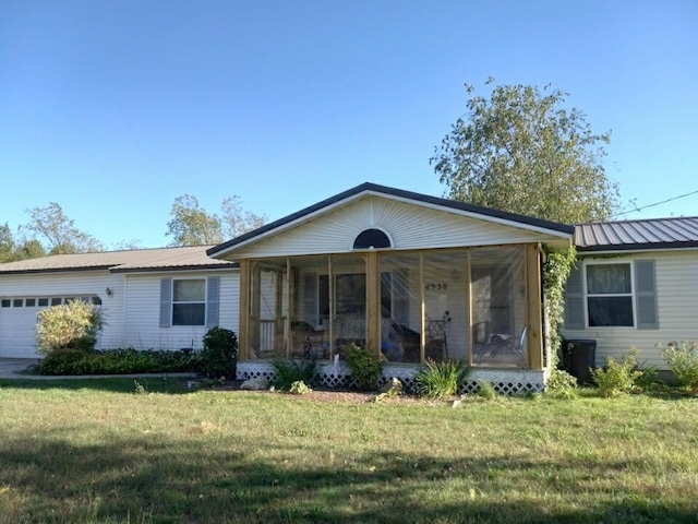 single story home with a front lawn, a garage, and a sunroom