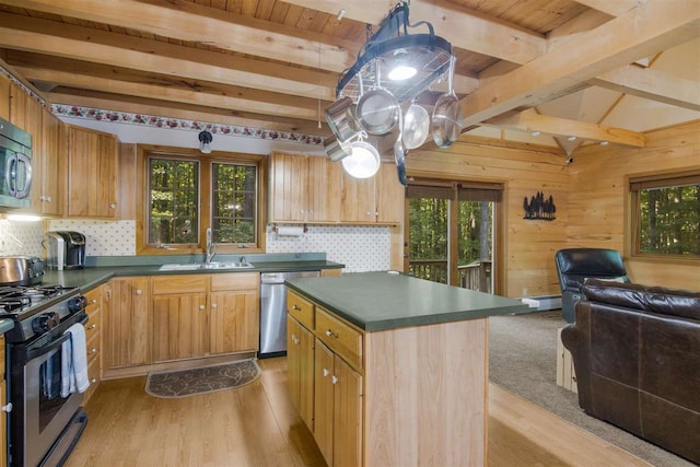 kitchen featuring a wealth of natural light, a center island, beamed ceiling, and appliances with stainless steel finishes