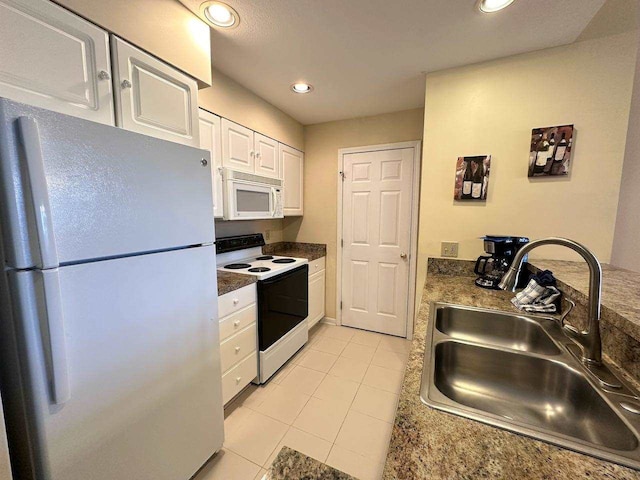 kitchen featuring light tile patterned flooring, white appliances, white cabinetry, and sink